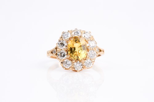 Lot 68 - A yellow sapphire and diamond cluster ring,...