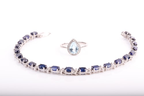Lot 221 - A 9ct white gold, diamond, and blue topaz ring,...