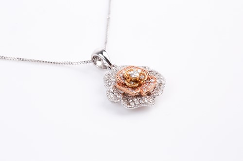 Lot 69 - A two colour 18ct gold and diamond flower head...