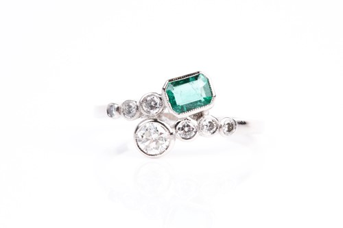 Lot 16 - An emerald and diamond crossover ring, with...