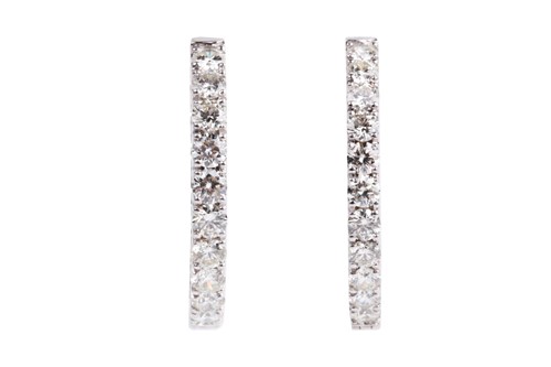 Lot 54 - A fine pair of diamond earrings, each set with...