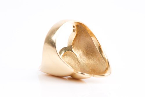 Lot 65 - A yellow metal elongated ring, of swept design,...
