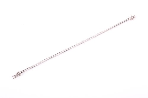 Lot 385 - A platinum and diamond line bracelet, the...