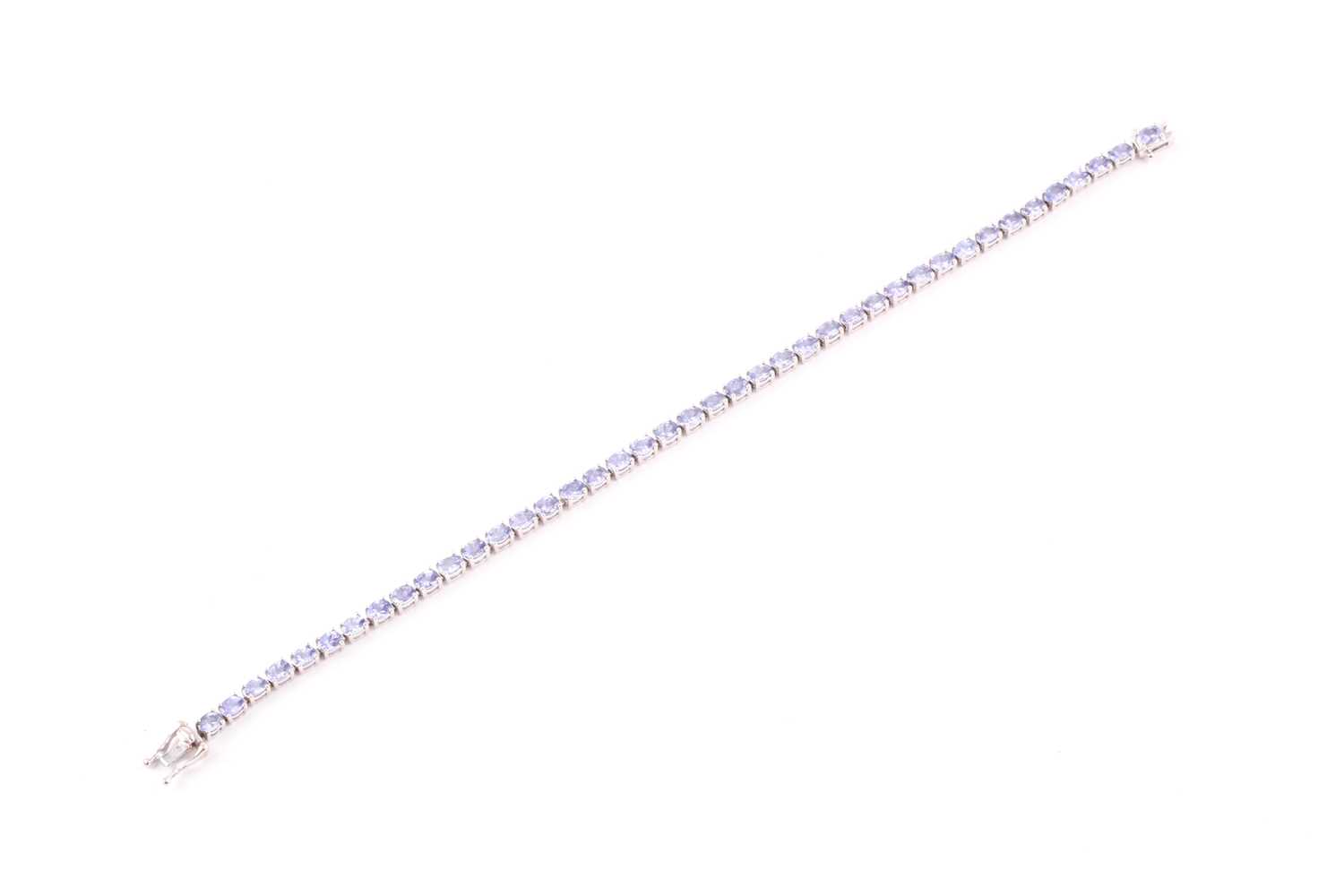Lot 132 - An 18ct white gold and tanzanite line bracelet,...