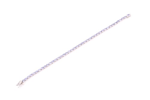 Lot 132 - An 18ct white gold and tanzanite line bracelet,...