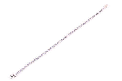 Lot 132 - An 18ct white gold and tanzanite line bracelet,...