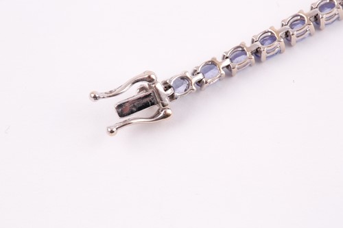 Lot 132 - An 18ct white gold and tanzanite line bracelet,...