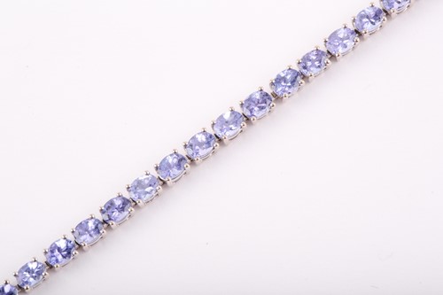 Lot 132 - An 18ct white gold and tanzanite line bracelet,...