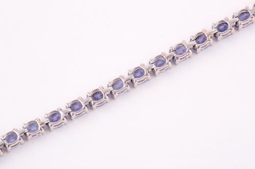 Lot 132 - An 18ct white gold and tanzanite line bracelet,...