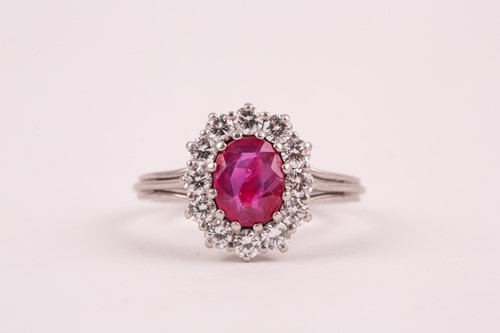 Lot 9 - A ruby and diamond cluster ring, the oval...