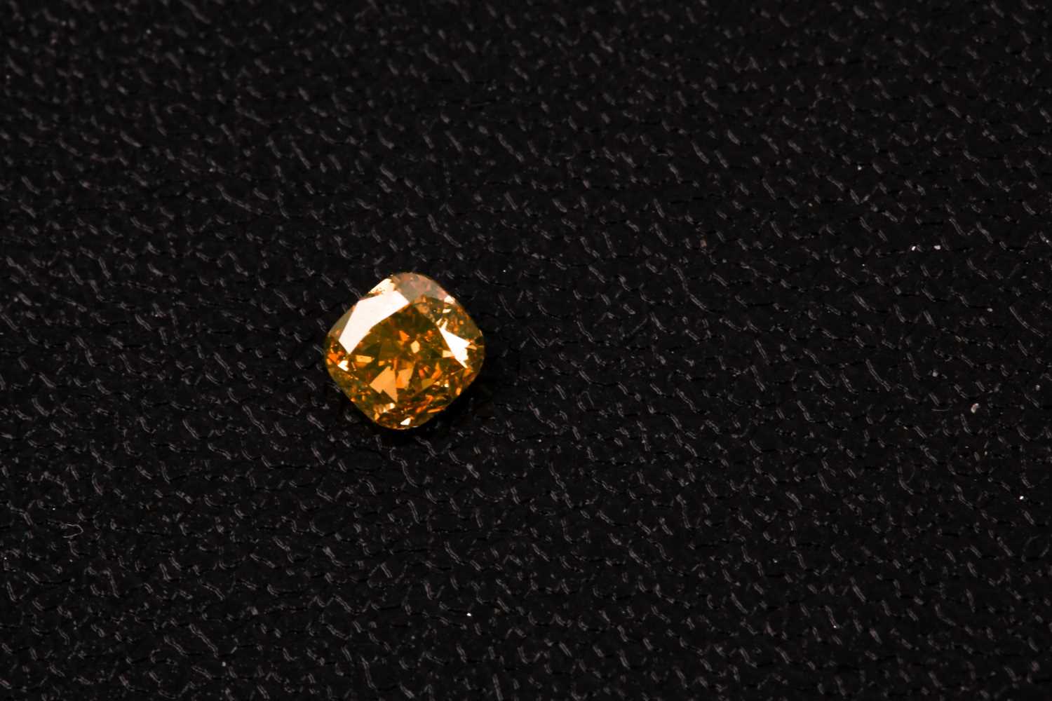 Lot 101 - A loose cushion-cut diamond, light orange,...