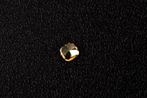 Lot 101 - A loose cushion-cut diamond, light orange,...
