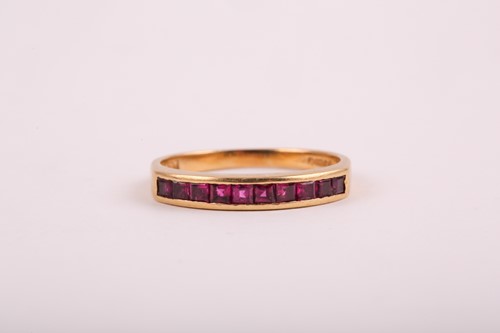 Lot 353 - An 18ct yellow gold and ruby ring, channel-set...