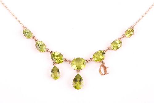 Lot 350 - A yellow metal and peridot drop pendant...