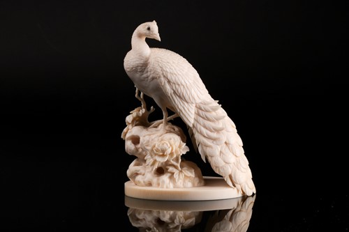 Lot 1 - A Japanese ivory okimono of a peacock, Meiji...