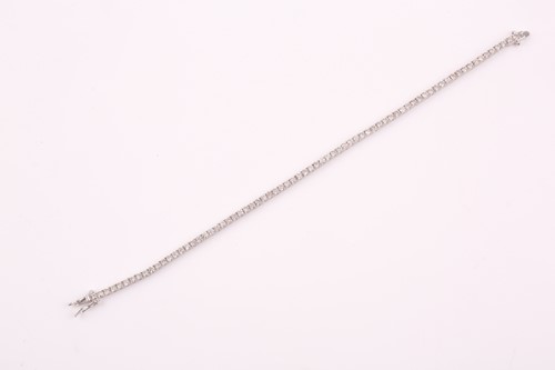 Lot 25 - An 18ct white gold and diamond line bracelet,...
