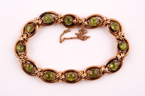 Lot 310 - A 9ct yellow gold and peridot bracelet, set...