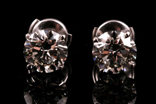 Lot 180 - A pair of round brilliant-cut diamond earrings,...