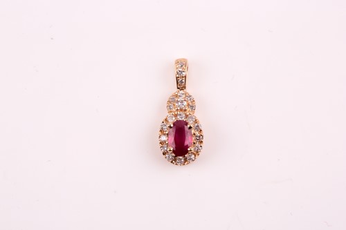 Lot 23 - A 14k yellow gold, diamond, and ruby pendant,...