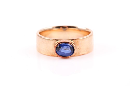 Lot 148 - A yellow metal and blue sapphire ring,...