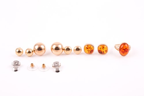 Lot 152 - A yellow metal and pressed amber ring, the...
