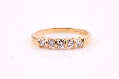 Lot 413 - A five stone diamond half hoop ring; the round...