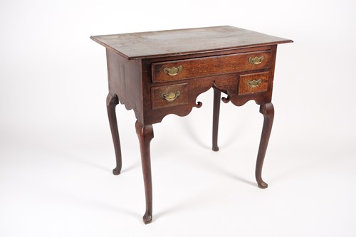 Lot 207 - An early 18th-century oak kneehole lowboy with...