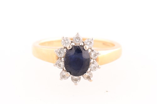 Lot 154 - A sapphire and diamond cluster ring; the oval...
