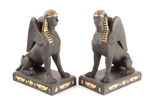 Lot 210 - A pair of Wedgwood gilded black basalt sitting...