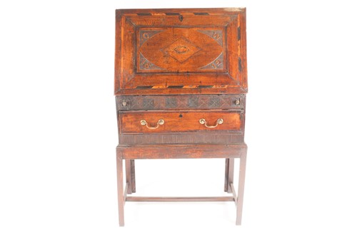 Lot 140 - A George III vernacular oak fall front writing...