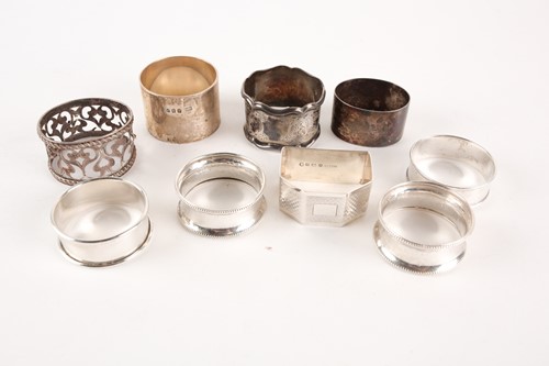 Lot 414 - A collection of nine silver napkin rings of...