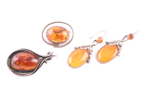 Lot 21 - Two silver and pressed amber brooches,...