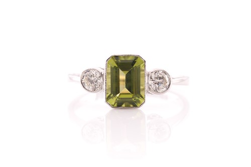 Lot 141 - A peridot and diamond three stone half hoop...