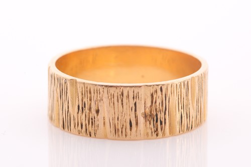 Lot 151 - An 18ct gold textured flat-section wedding...