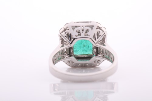 Lot 34 - An emerald and diamond square cluster ring,...