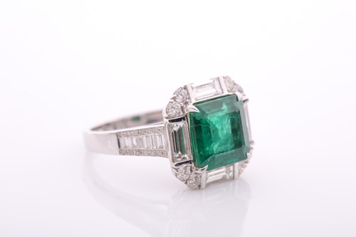 Lot 34 - An emerald and diamond square cluster ring,...