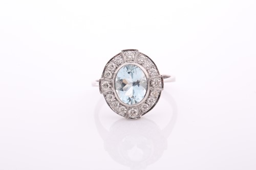 Lot 90 - An aquamarine and diamond oval cluster ring in...