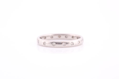 Lot 142 - A diamond eternity band, the white metal shank...