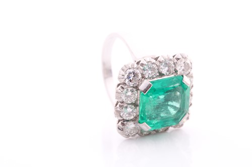 Lot 119 - An emerald and diamond cluster ring; the...