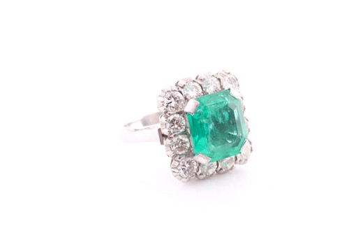 Lot 119 - An emerald and diamond cluster ring; the...