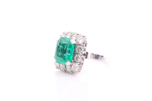 Lot 119 - An emerald and diamond cluster ring; the...