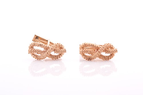 Lot 296 - A pair of yellow metal knot-design cufflinks,...