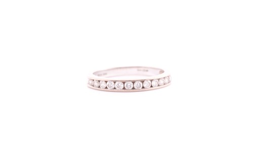 Lot 136 - A twelve stone half hoop diamond eternity ring;...