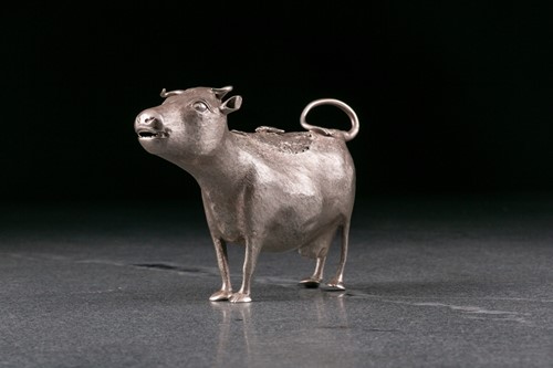 Lot 355 - A George III silver cow creamer. London 1764...
