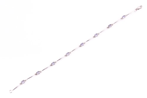 Lot 81 - A 9ct white gold, diamond, and tanzanite line...