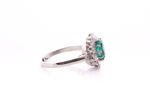 Lot 21 - A platinum, diamond, and emerald cluster ring,...