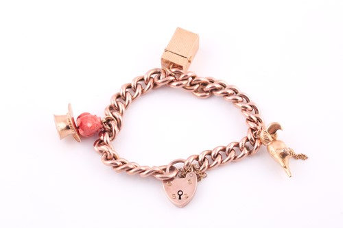 Lot 18 - A 9ct rose gold curb-lik charm bracelet, with...