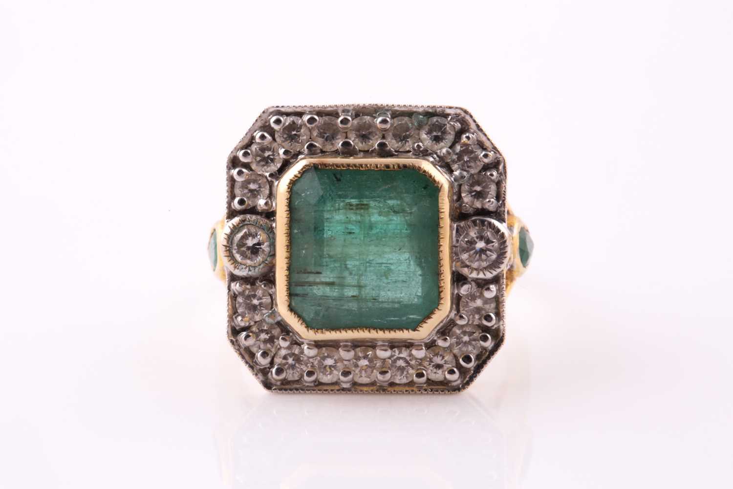 Lot 20 - An emerald and diamond cluster ring. The...