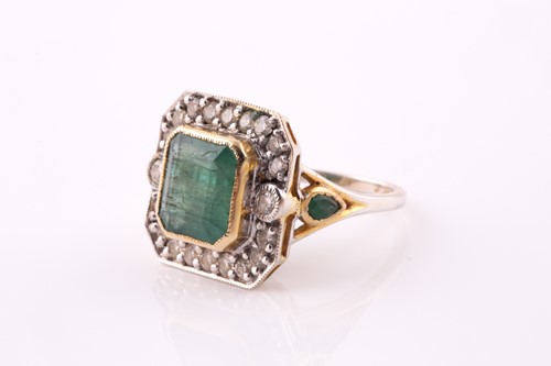 Lot 20 - An emerald and diamond cluster ring. The...