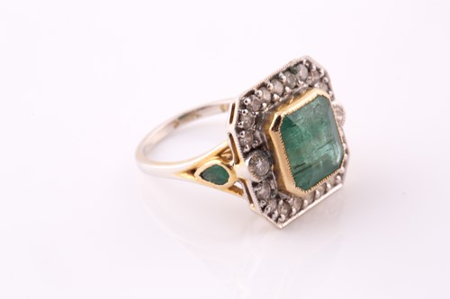 Lot 20 - An emerald and diamond cluster ring. The...
